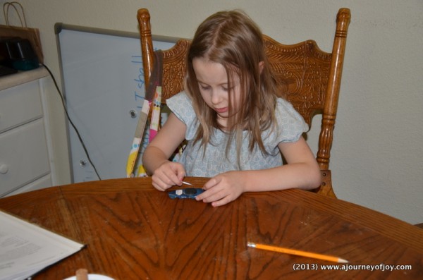 Claire running the needle over the magnet.