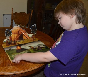 Samuel looking at the Tower of Babel Pop-Up Book.